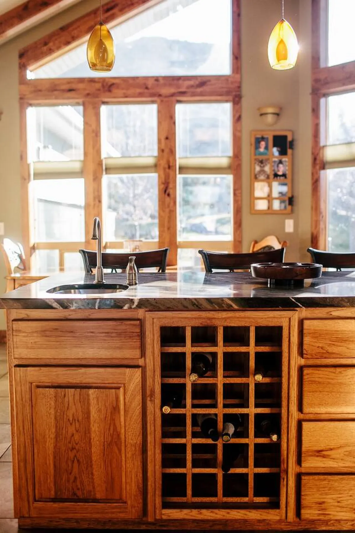 A bright and spacious gourmet kitchen with a large island, built-in wine rack, and plenty of natural light streaming in through generous windows. The space is designed for cooking, entertaining, and relaxed family gatherings.